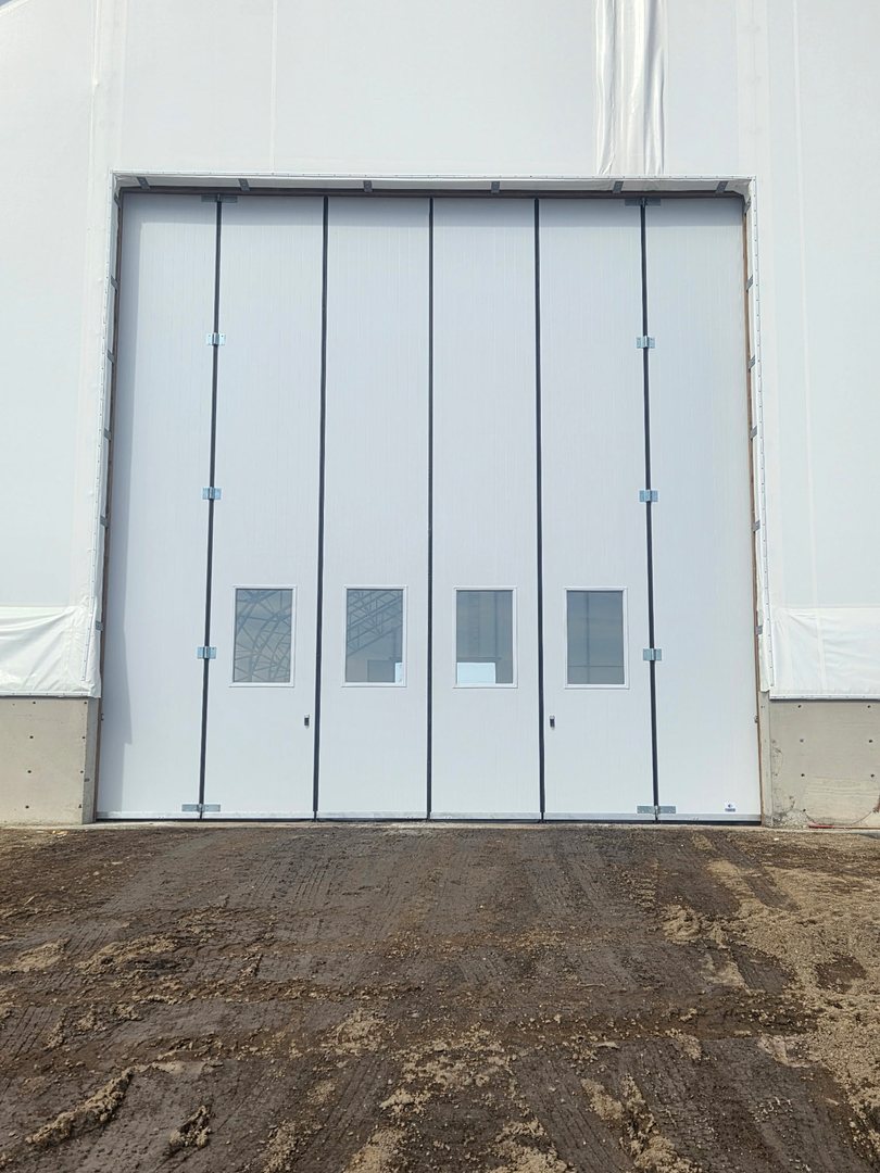 White folding door fitted to a large commercial opening