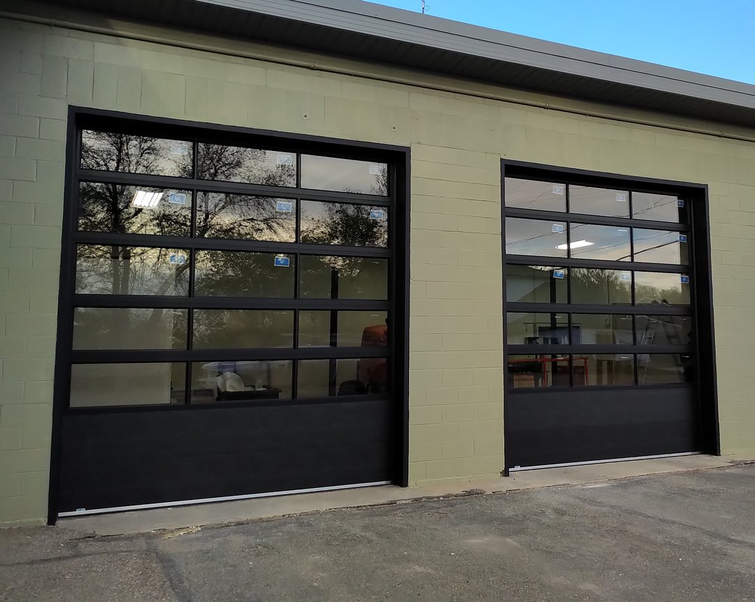 Two black full-view aluminium doors on a commercial building