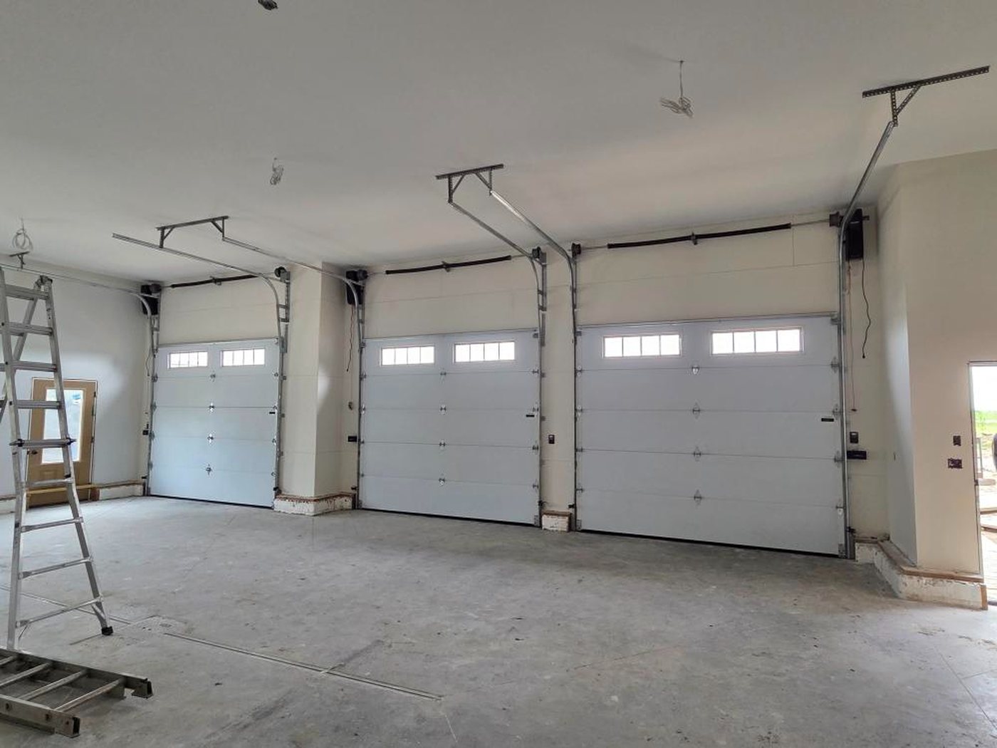 Interior of a commercial shop with several white overhead doors
