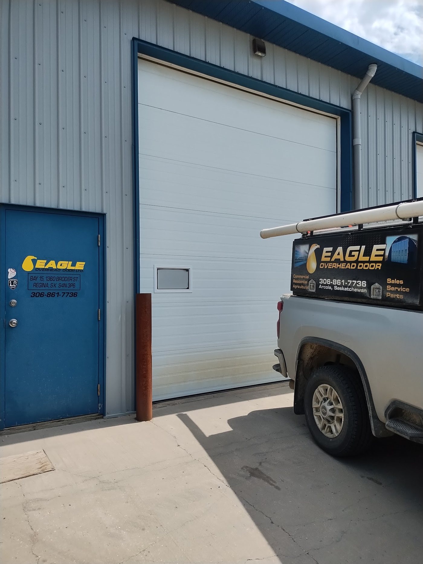 Eagle Overhead Door truck parked at a blue commercial shop