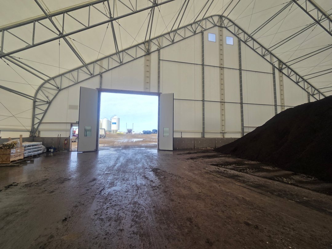 Overhead door in an arched fabric-covered farm building