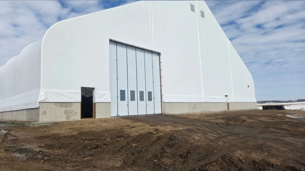 White fabric-covered building with new overhead doors