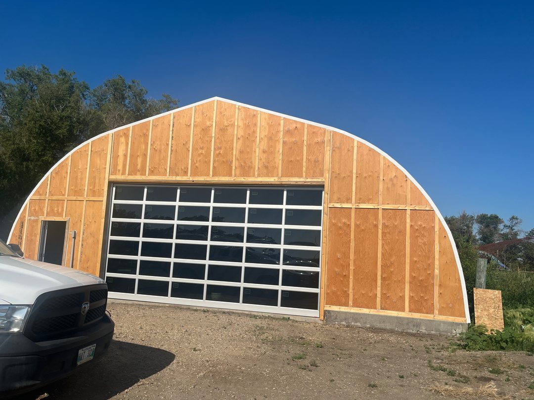 Full-view overhead doors fitted to an arched quonset building