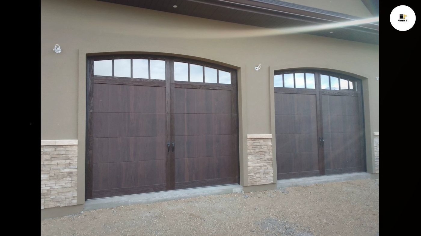 Two woodgrain carriage-style garage doors with arched windows