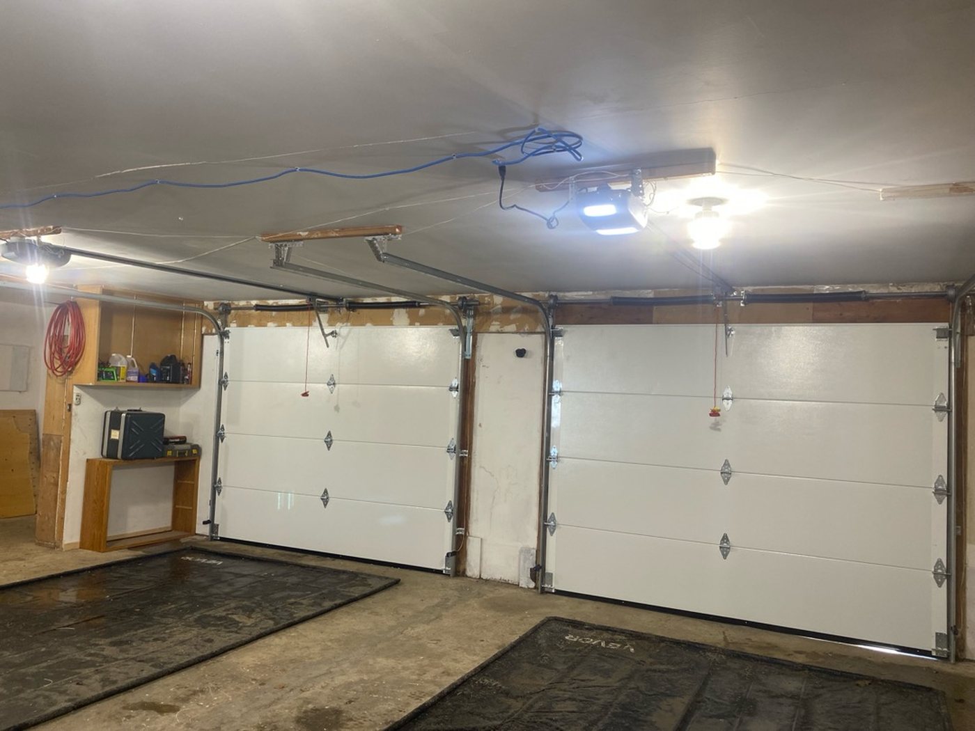 Two white garage doors seen from inside a finished garage