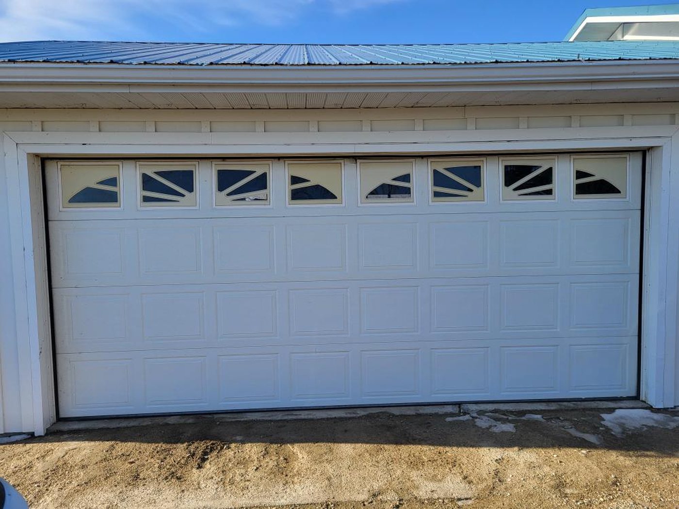 White garage door with a row of sunburst windows