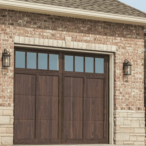 Woodgrain carriage-house garage door with windows on a brick home