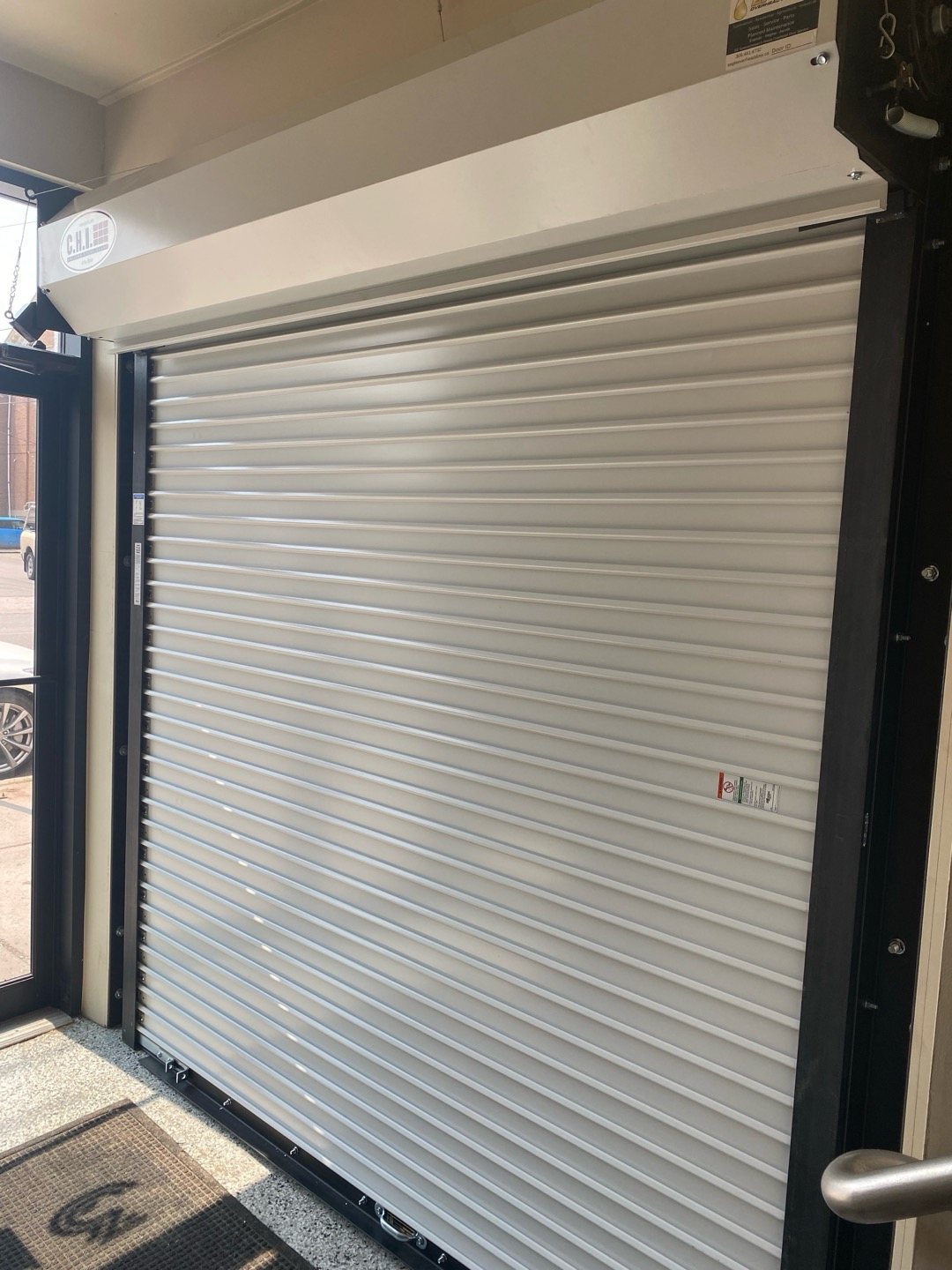 White rolling steel door coiled above a commercial opening